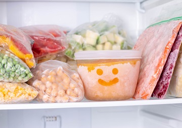 Ein Kühlschrank gefüllt mit Lebensmitteln in Boxen und Frischhaltebeutel.